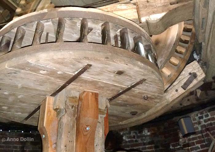 Huge wooden interlocking gear wheels that are part of the mechanism inside the Steenmeulen windmill in France. 