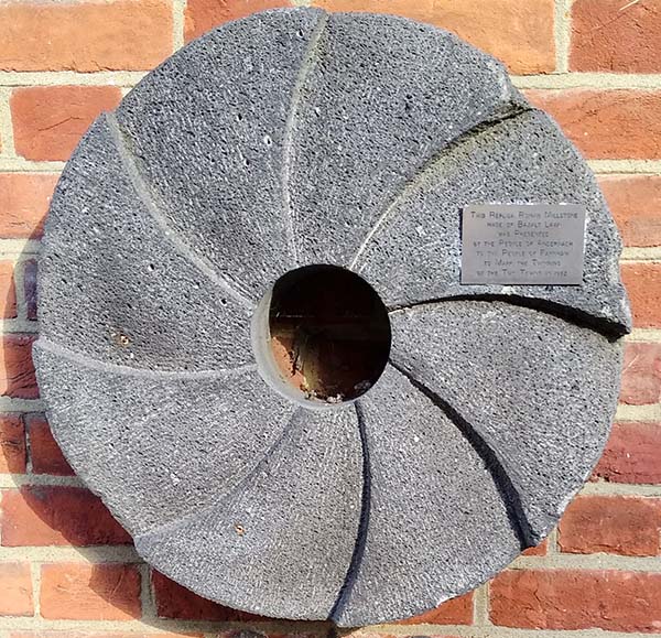 A commemorative Cullin millstone made in Andernach, Germany from a basalt-like stone containing many small holes or vesicles.